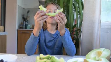 Evde yemek yiyip içki içen çocuk. Bir çocuğun yemek ve içecekten keyif aldığı sakin bir gün, sağlıklı bir rutin, aile hayatı, sıradan bir ev hayatı, doğal çocukluk aktivitesi..