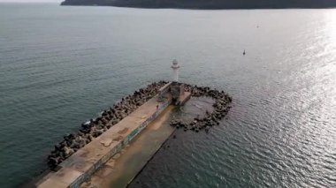 Bulgaristan 'ın Varna Limanı' ndaki deniz fenerinin hava görüntüsü. Sakin Karadeniz suları, kıyı kenti ufuk çizgisi ve deniz manzarası.