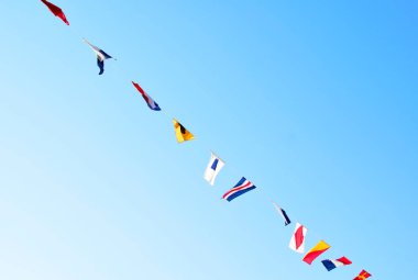 Açık mavi gökyüzüne karşı renkli bayraklar, Trieste, İtalya