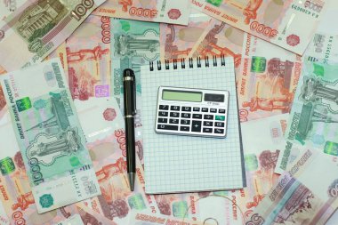 Hesap makinesi, kalem, defter yalan Rus m arka plan üzerinde