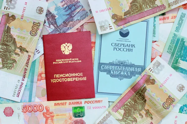 Пенсійні картки та ощадні книги на тлі російських м — стокове фото