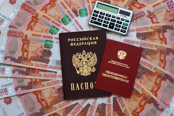 Passport, a calculator and a pension certificate on money backgr
