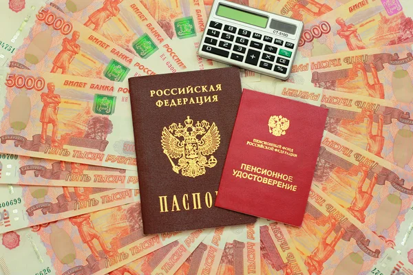 Passport, a calculator and a pension certificate on money backgr