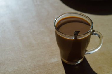 Kahve fincanının fotoğrafı. Masada süt var.