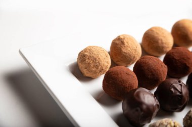 variety of handmade gourmet chocolate truffle candy on a white plate