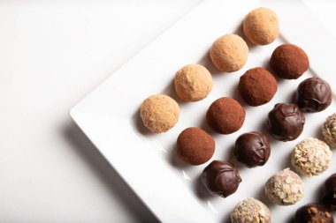 variety of handmade gourmet chocolate truffle candy on a white plate