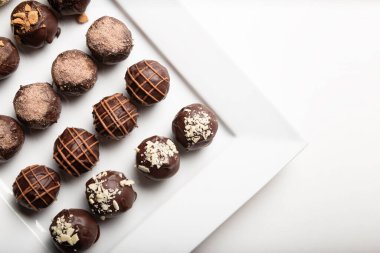 variety of handmade gourmet chocolate truffle candy on a white plate