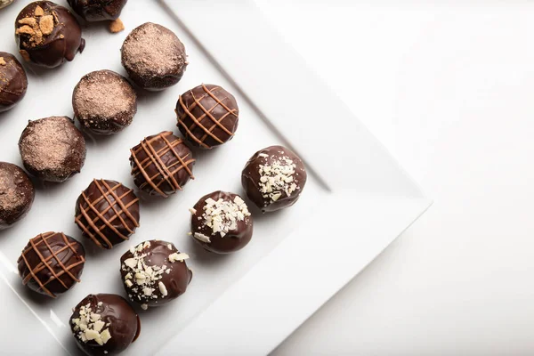 variety of handmade gourmet chocolate truffle candy on a white plate