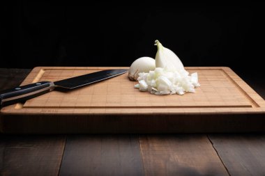 Bambu kesme tahtasında taze doğranmış beyaz soğan. Allium cepa. Siyah arkaplan