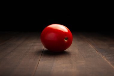 Kırsal ahşap yüzeye yakın bir domates resmi ve siyah arkaplan