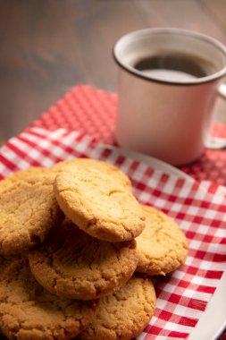 Ev yapımı çıtır kurabiyeler ve ahşap kırsal masada Amerikan kahve fincanı.