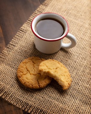 Ev yapımı çıtır kurabiyeler ve ahşap kırsal masada espresso fincanı.