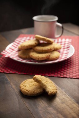 Ev yapımı çıtır kurabiyeler ve ahşap kırsal masada bir kahve fincanı.