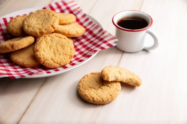 Ev yapımı çıtır kurabiyeler ve beyaz ahşap kırsal masada espresso fincanı.