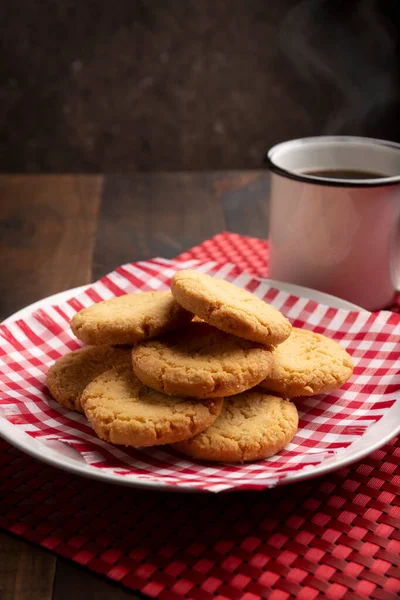 自制的脆饼干和放在木制乡村餐桌上的咖啡杯 — 图库照片