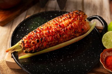 Izgara mısır. Tipik bir Meksika sokak yemeği, Elote Asado olarak bilinir, kömürle kızartılmış mısır koçanı, limon ve piquin biber tozuyla yenir..