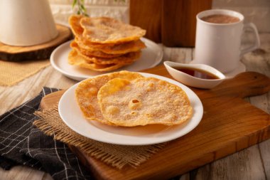 Mexican Bunuelos. Traditional food at Christmas and winter holidays in Mexico, these are fried flour tortillas sprinkled with sugar or covered in a syrup made with piloncillo, cinnamon, and guava.