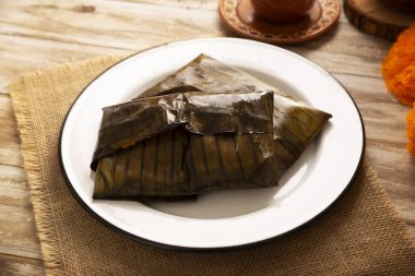 Oaxacan Tamales. A pre-Hispanic dish typical of Mexico and some Latin American countries. Corn dough wrapped in banana leaves is filled with meat or a stew. Tamales are steamed.