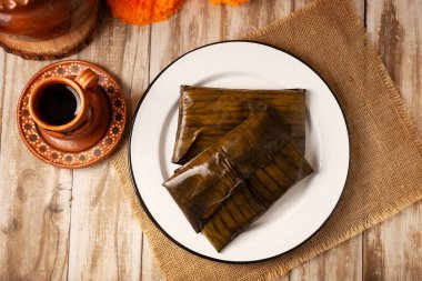 Oaxacan Tamales. A pre-Hispanic dish typical of Mexico and some Latin American countries. Corn dough wrapped in banana leaves is filled with meat or a stew. Tamales are steamed.