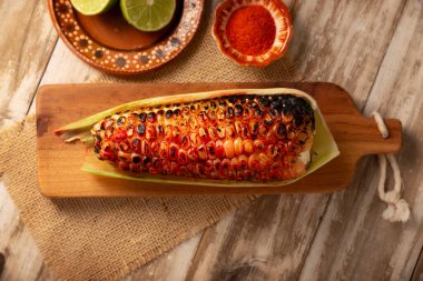 Meksika usulü ızgara mısır koçanı. Tipik bir Meksika sokak yemeği, Elote Asado olarak bilinir, kömürle kızartılmış mısır koçanı, limon ve acı biber tozuyla yenir..