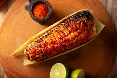 Meksika usulü ızgara mısır koçanı. Tipik bir Meksika sokak yemeği, Elote Asado olarak bilinir, kömürle kızartılmış mısır koçanı, limon ve acı biber tozuyla yenir..