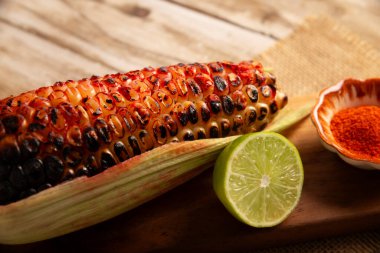 Meksika usulü ızgara mısır koçanı. Tipik bir Meksika sokak yemeği, Elote Asado olarak bilinir, kömürle kızartılmış mısır koçanı, limon ve acı biber tozuyla yenir..