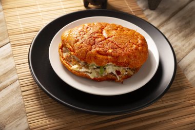 Pambazo. Meksika sandviçi kırmızı sosla marine edildi ve geleneksel olarak Meksika sokak yemeklerinin klasik bir örneği olan patates ve sucukla dolduruldu..