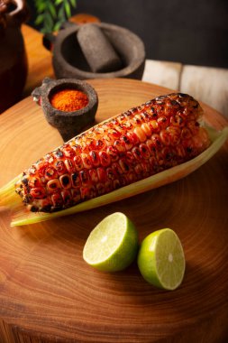 Meksika usulü ızgara mısır koçanı. Tipik bir Meksika sokak yemeği, Elote Asado olarak bilinir, kömürle kızartılmış mısır koçanı, limon ve acı biber tozuyla yenir..