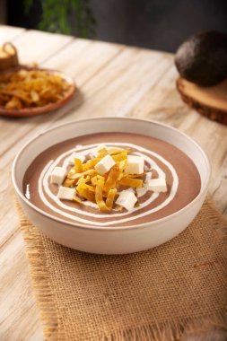 Creamy bean soup. In Mexico known as Crema de Frijoles, nutritious homemade food recipe, commonly accompanied with cheese, cream, avocado and corn tortilla cut into strips and fried.