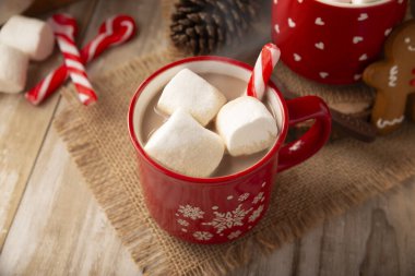 Marşmelovlu sıcak çikolata, Noel zamanı ve bayramlarda yapılan geleneksel sıcak bir içecek. Kırmızı bardakta servis edilir ve zencefilli kurabiyelerle birlikte....