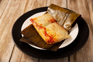 Oaxacan tamale 'leri. Meksika ve Latin Amerika ülkelerinden tipik yemekler. Genellikle kahvaltıda ya da akşam yemeğinde servis edilir. Muz yapraklarına sarılı mısır hamuru ve et ya da güveç ile dolu. Buharlı aşçı.