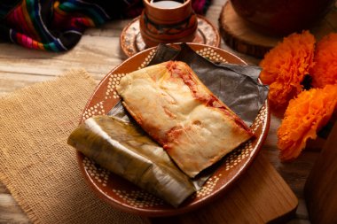Oaxacan tamale 'leri. Meksika ve Latin Amerika ülkelerinden tipik yemekler. Genellikle kahvaltıda ya da akşam yemeğinde servis edilir. Muz yapraklarına sarılı mısır hamuru ve et ya da güveç ile dolu. Buharlı aşçı.