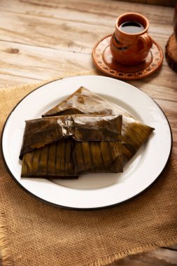 Oaxacan tamale 'leri. Meksika ve Latin Amerika ülkelerinden tipik yemekler. Genellikle kahvaltıda ya da akşam yemeğinde servis edilir. Muz yapraklarına sarılı mısır hamuru ve et ya da güveç ile dolu. Buharlı aşçı.