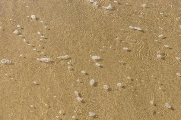 Wet sand at the beach and the water foam. Background. — Stock Photo, Image