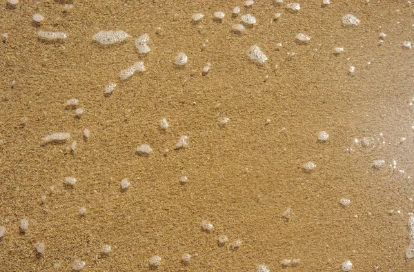 Wet sand at the beach and the water foam. Background. — Stock Photo, Image