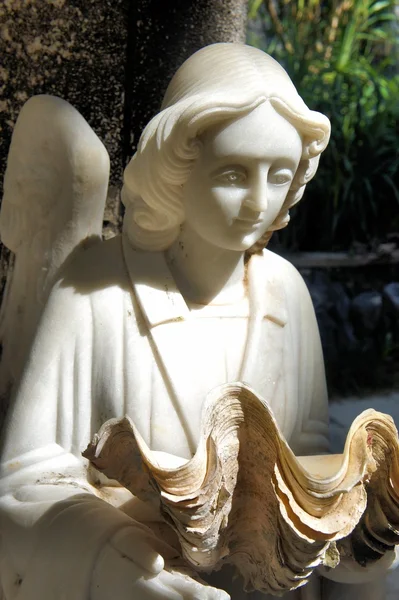 Sculpture of an angel with a sea shell . Philippines. — Stock Photo, Image