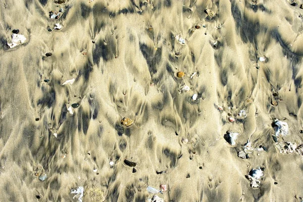 Der nasse Sand am Strand und der Wasserschaum. Hintergrund. — Stockfoto