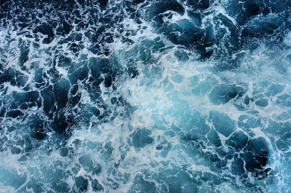 Beyaz köpük mavi deniz yüzeyi. Gemiden iz.