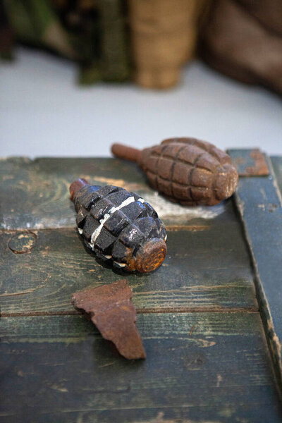 Старые военные ручные гранаты на выветренной поверхности. Старое оружие, которое использовалось в русско-украинской войне