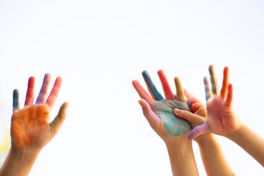 Gülümseyen yüzlü parlak boyalı eller neşe, masumiyet, yaratıcılık ve neşe dolu birlik çocukluk ve beraberliğin coşkulu bir kutlaması.