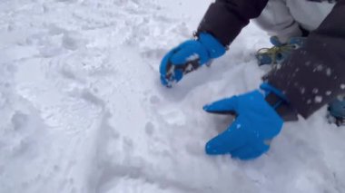 Çocukların karda birlikte kartopu yapmaları, dışarıda gülüp oynamaları eğlence ve tatil enerjisiyle dolu neşeli bir kış aktivitesi..