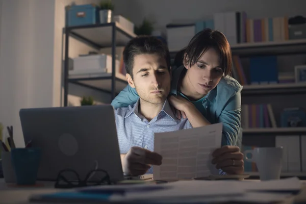 Paar checkt nachts Rechnungen — Stockfoto