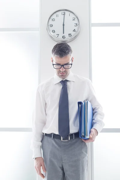 Businessman standing under a clock — Stock fotografie