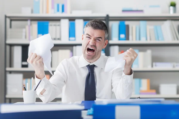 Homem de negócios irritado trabalhando na mesa de escritório — Fotografia de Stock