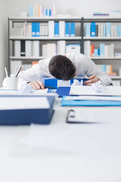 Homme d'affaires dormant sur son bureau — Photo