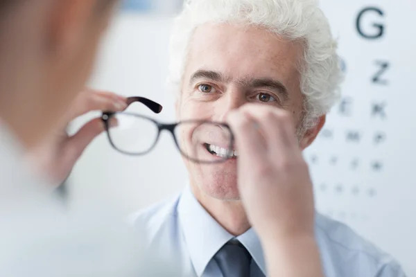 Ottico che dà nuovi occhiali al paziente — Foto Stock
