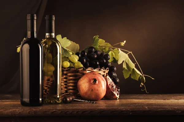 Wine bottles, corkscrew and grapes — Stock Photo, Image