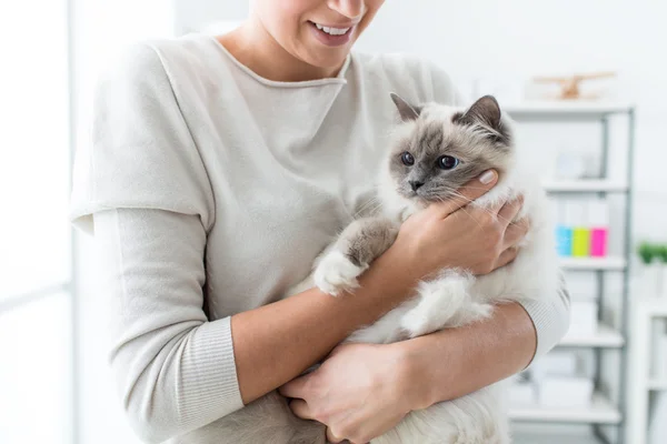 Femme à la maison tenant chat — Photo