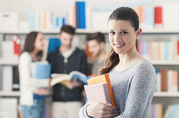 Estudante menina posando na biblioteca — Fotografia de Stock