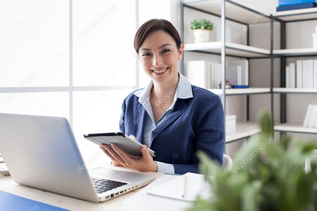 Smiling office worker using a tablet